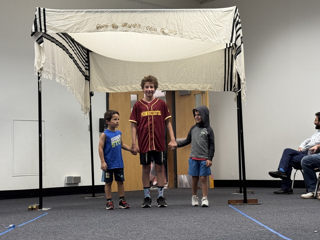 K-8 buddies walk through chuppah at Smith Opening Ceremony