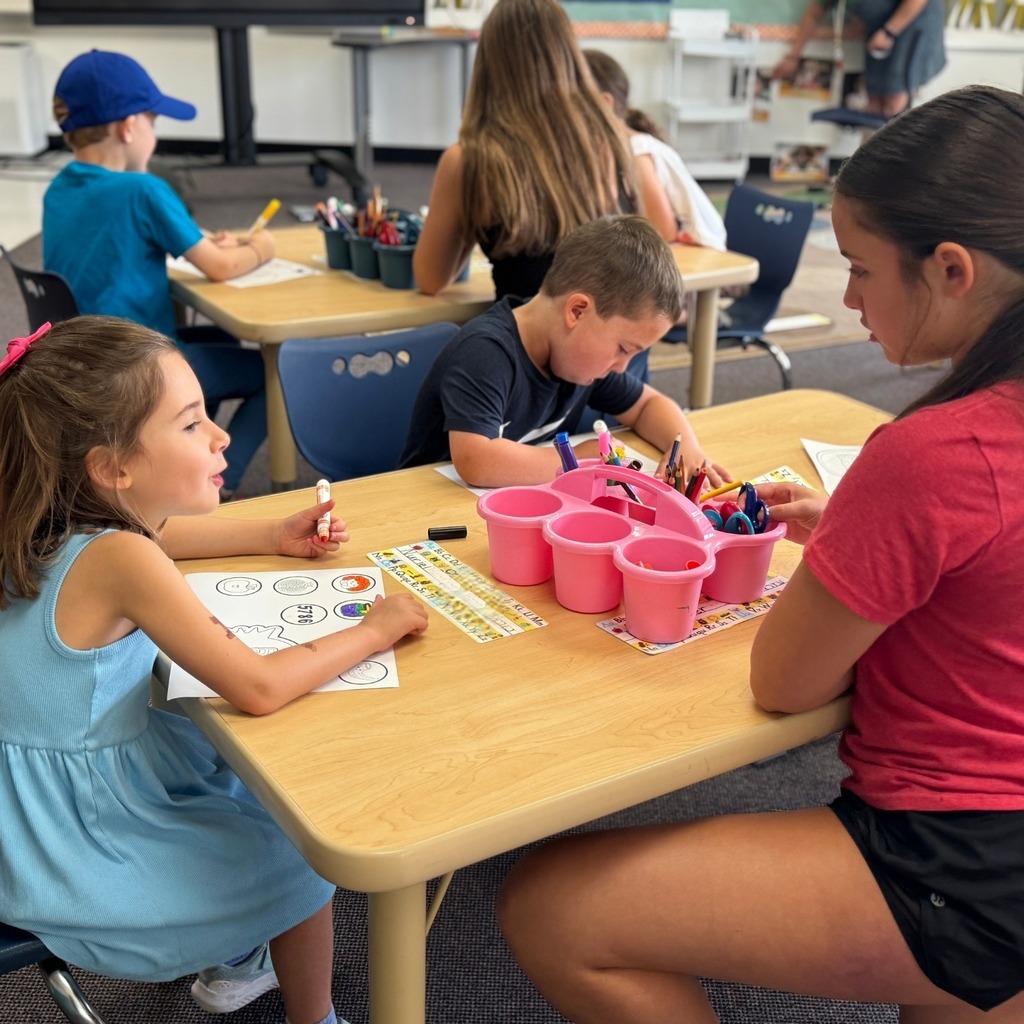 kindergartners color Rosh Hashanah crowns with eighth grade buddy