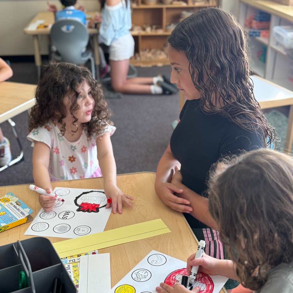 kindergartners color Rosh Hashanah crowns with eighth grade buddy