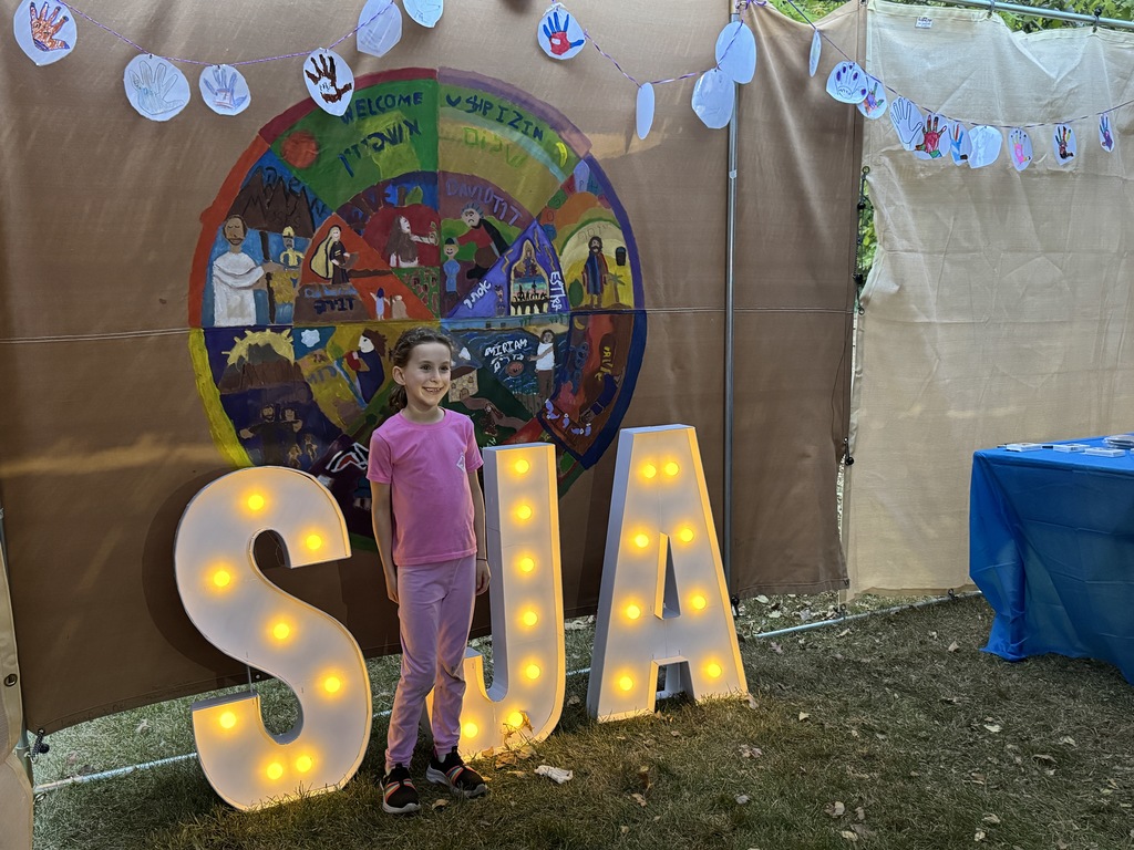 student poses for photo for art project