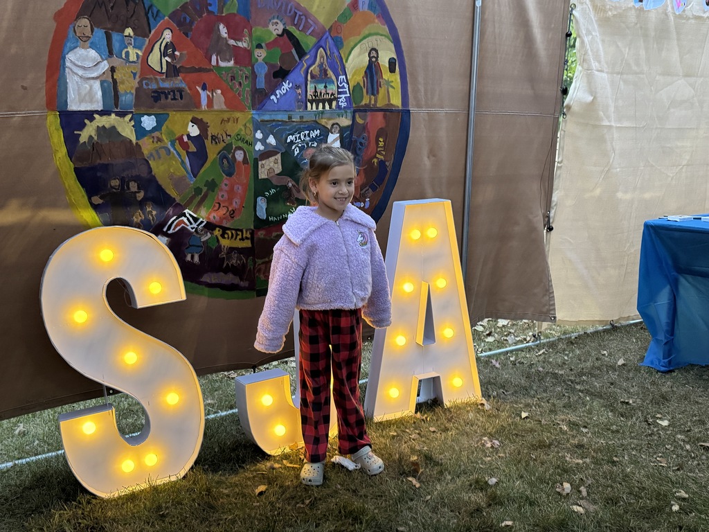 student poses for photo for art project