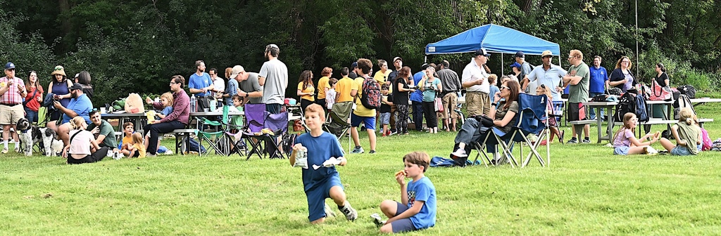 students, parents, and community members eat dinner and watch the soccer game