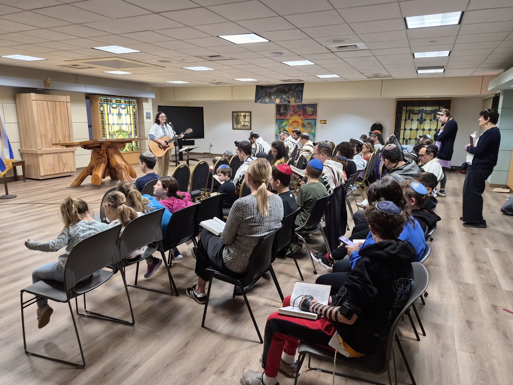 rabbi with guitar leads shacharit for families
