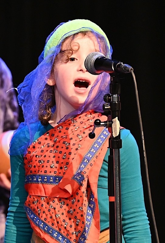 first grader speaks into microphone