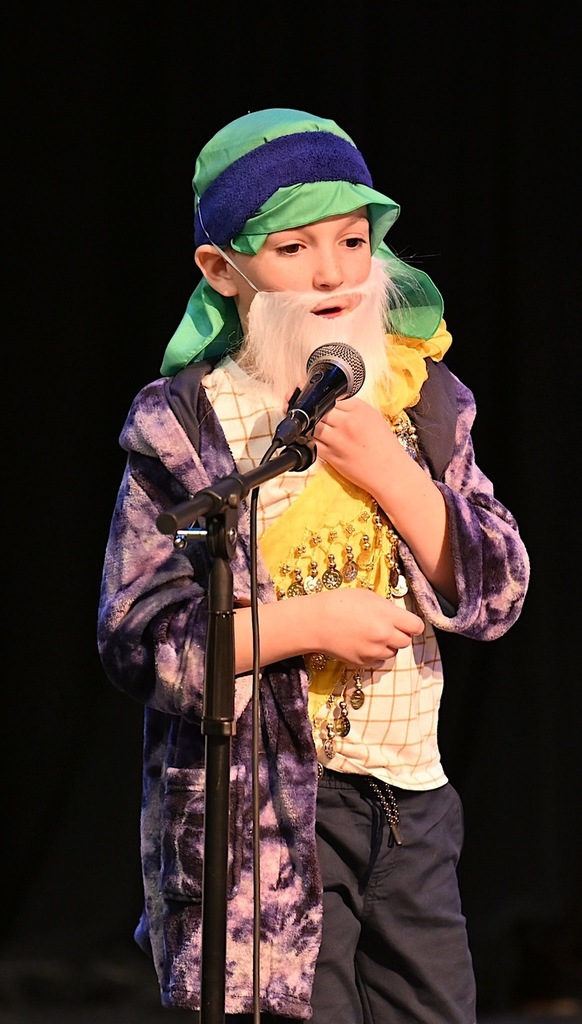 first grader speaks into microphone