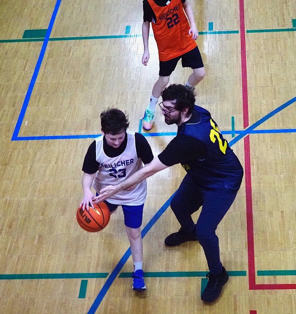 alum defends against student with basketball