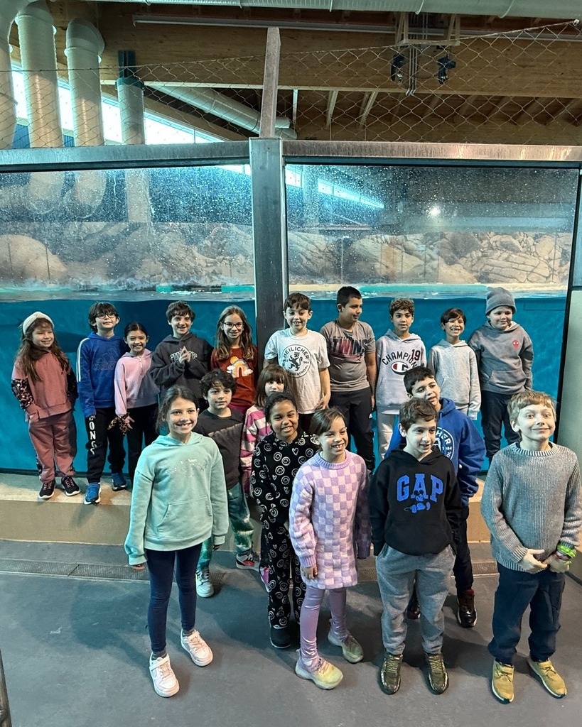third graders pose in front of aquarium