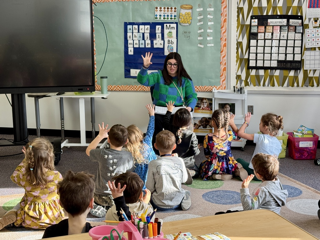 SJA kindergarten teacher teaches interactive phonics, teacher and students raise hands to practice