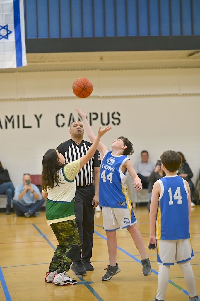 basketball players jump for ball to start game