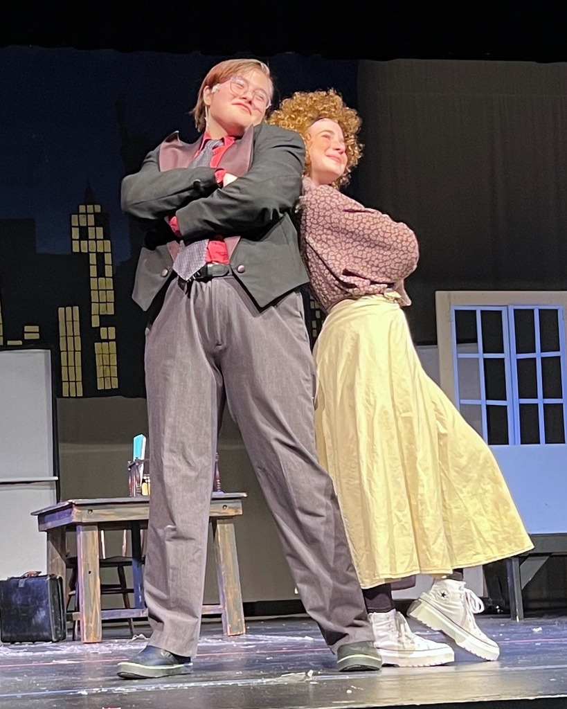 Oliver Warbucks and Annie pose back-to-back