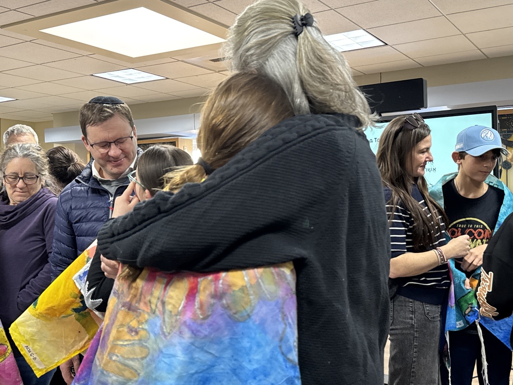 mother hugs daughter who is wearing her talit