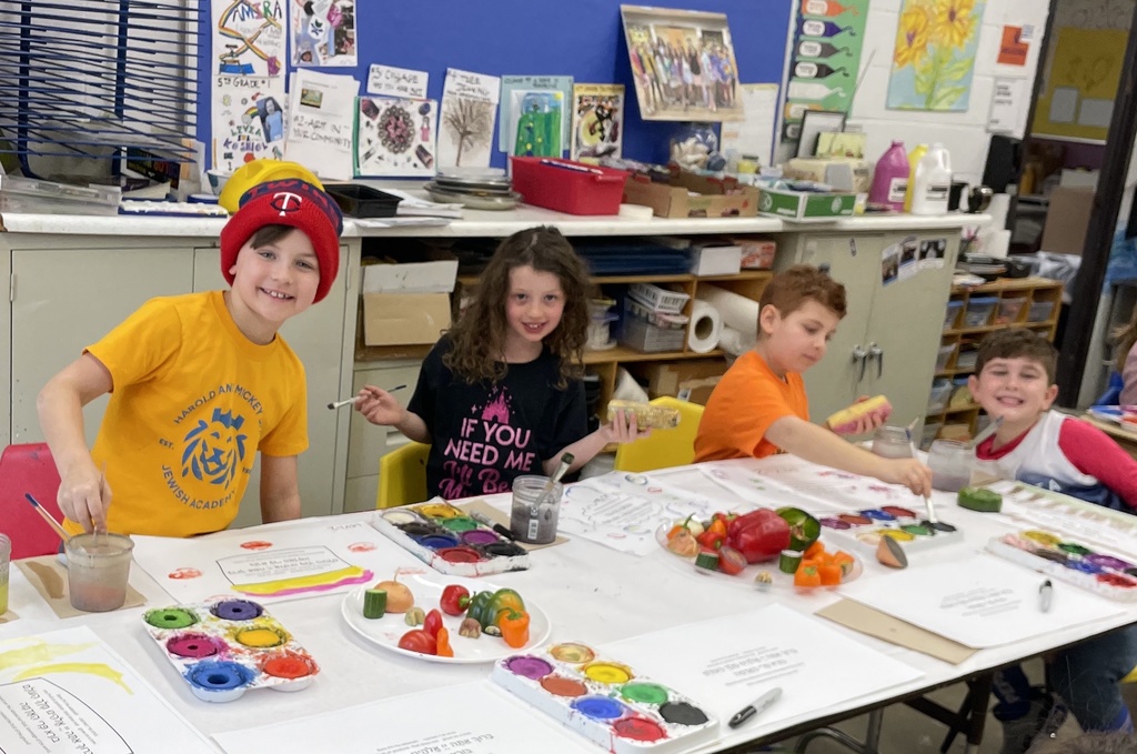 students paint fruits and vegetables to stamp