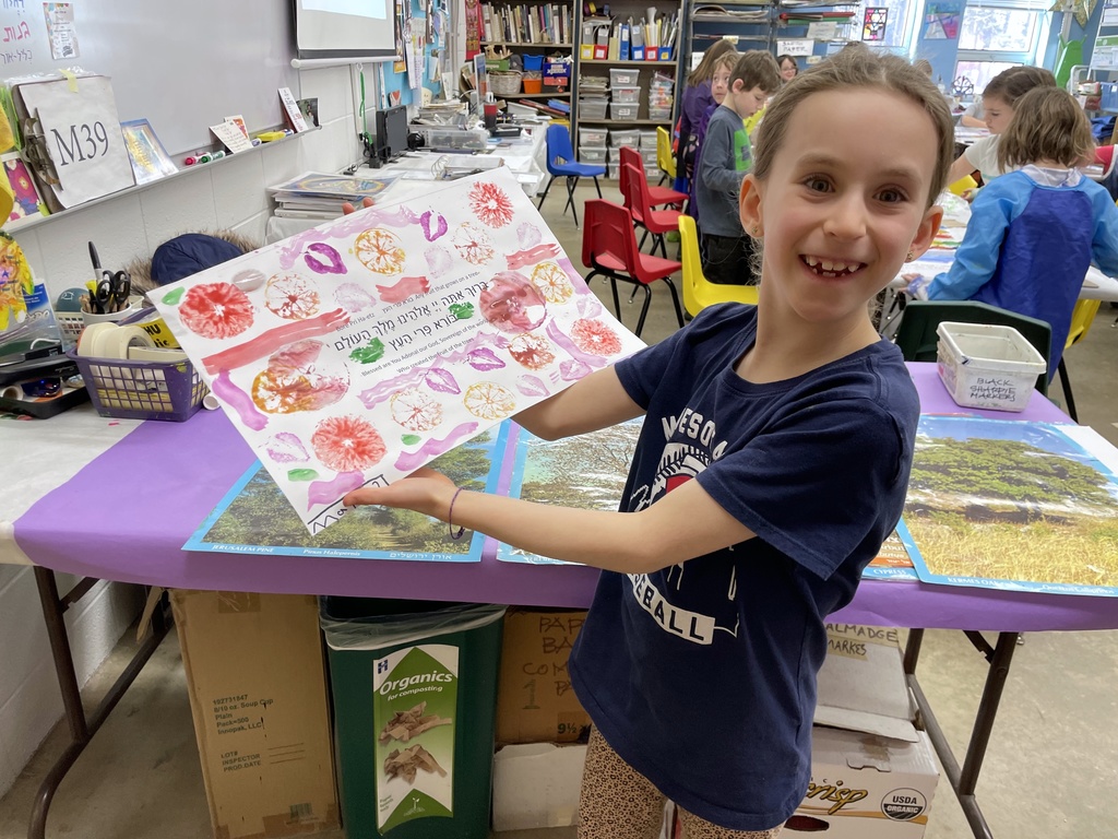 student shows fruit-stamped art for tree fruit blessing