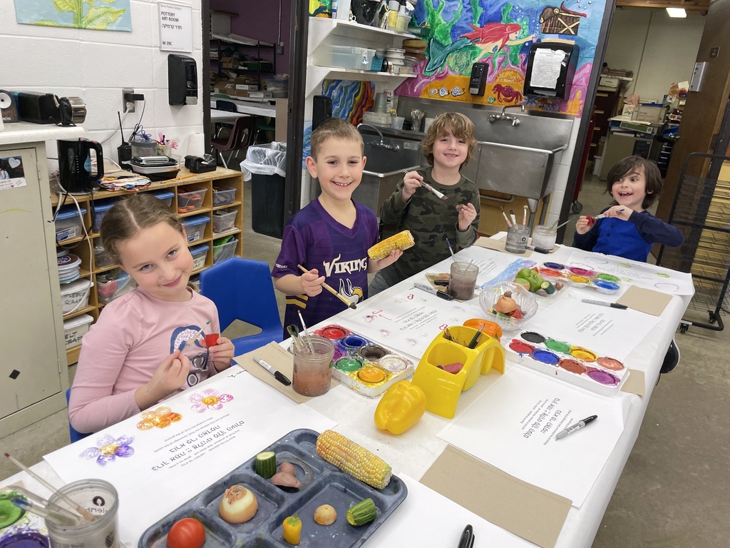 students paint fruits and vegetables to stamp