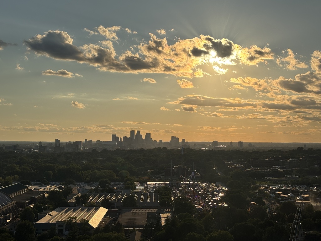 sun shines orange into the blue city skyline
