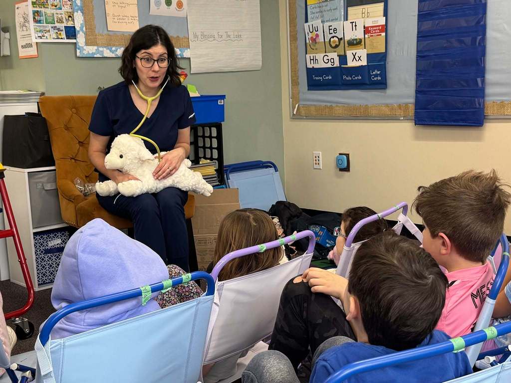 vet talks to first graders with stuffed animal lamb