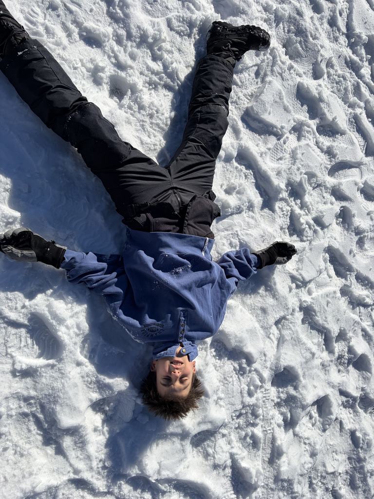 boy lies in snow