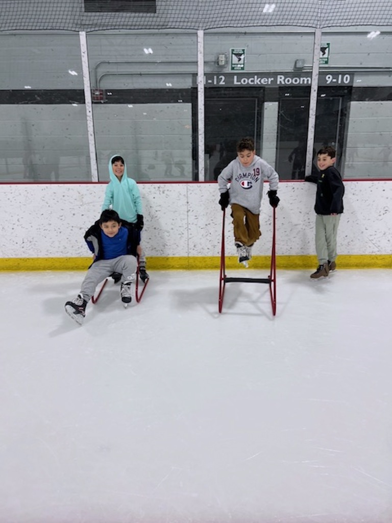 four boys on the ice rink