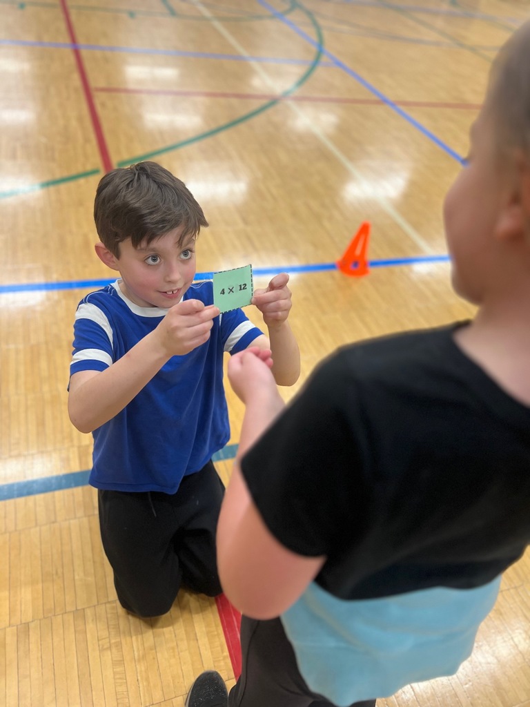 student shows equation to other student in multiplication freeze tag