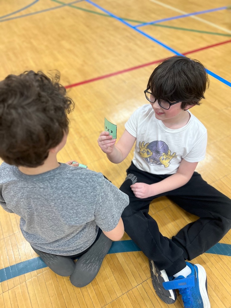 student shows equation to other student in multiplication freeze tag