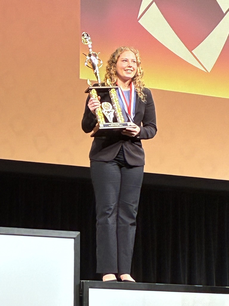 Laila Schoenberger holds DECA trophy