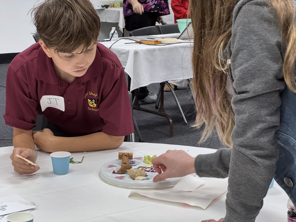 Smith student shows seder plate to Good Shepherd student