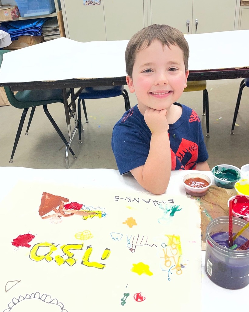 kindergarten student poses with hand-painted matzah cover