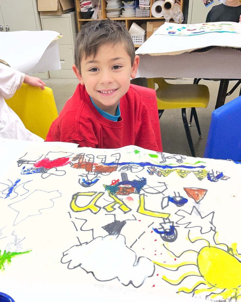 kindergarten student poses with hand-painted matzah cover