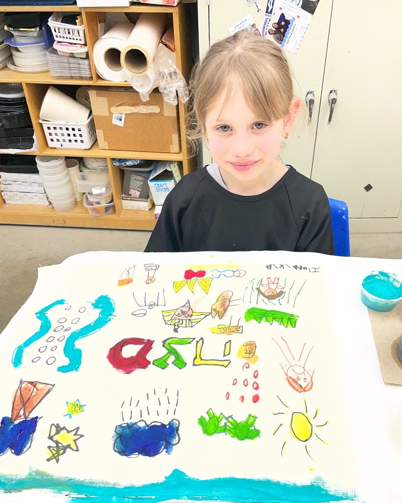 kindergarten student poses with hand-painted matzah cover