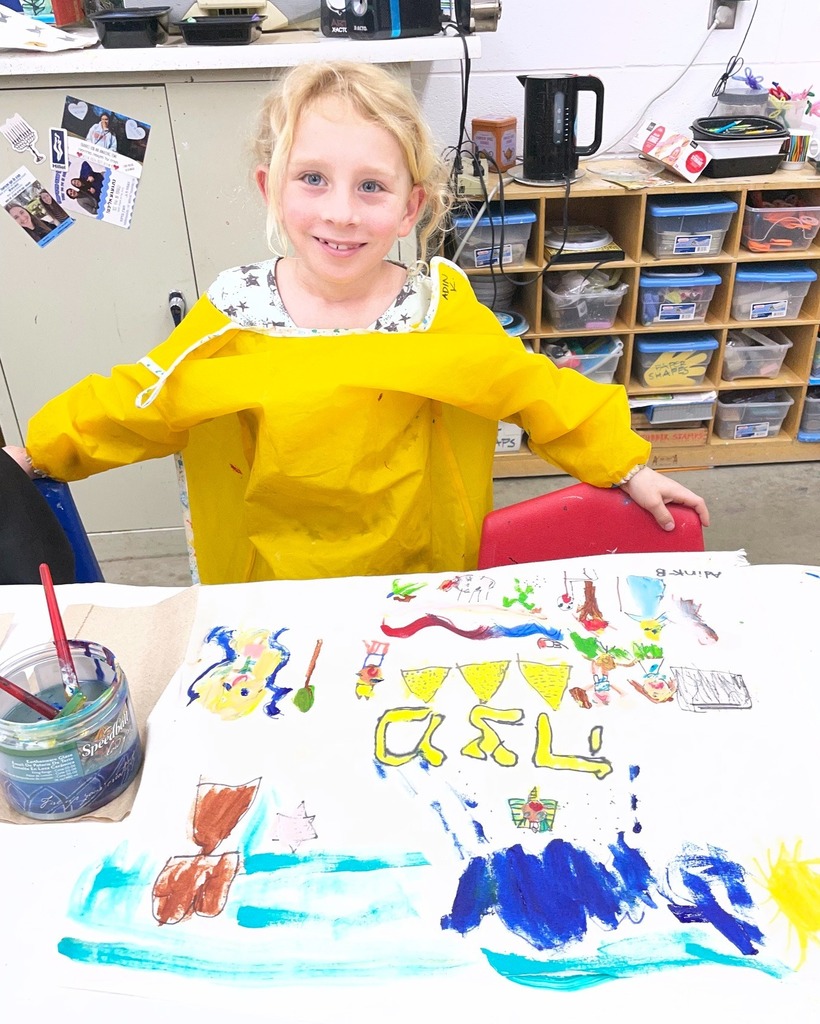 kindergarten student poses with hand-painted matzah cover