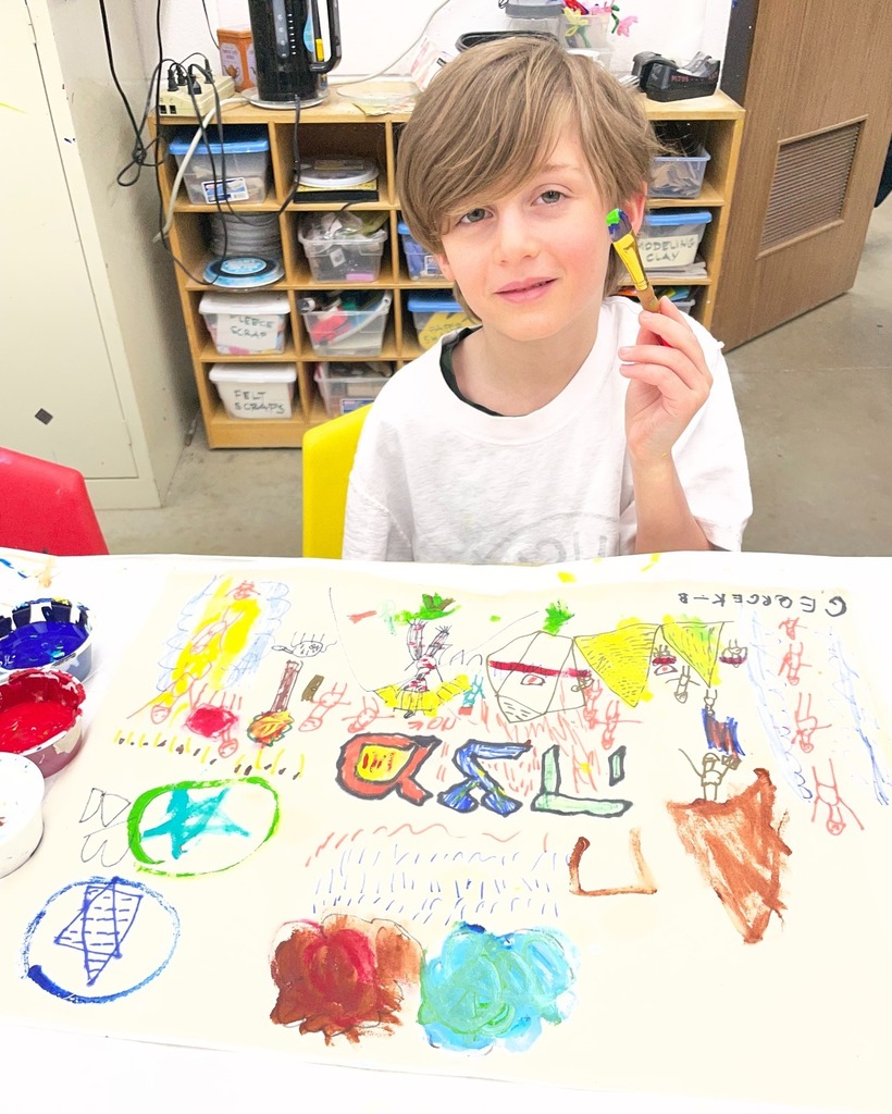 kindergarten student poses with hand-painted matzah cover