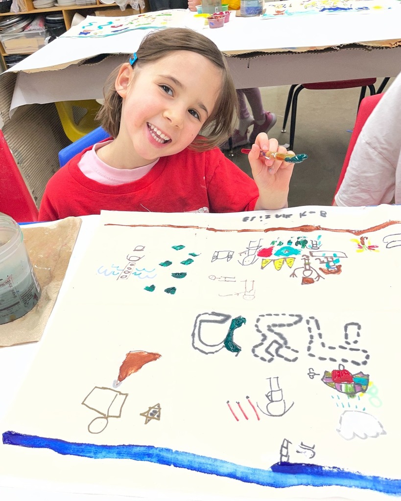 kindergarten student poses with hand-painted matzah cover