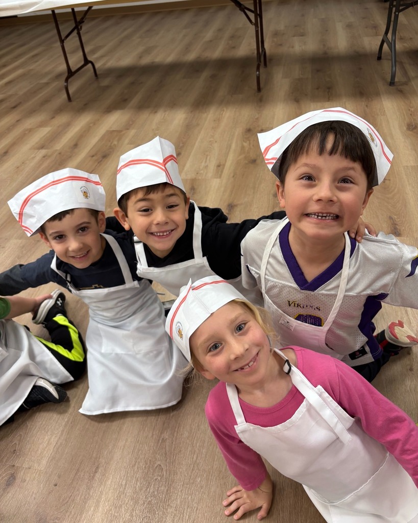 kindergartners in aprons and baker hats smile