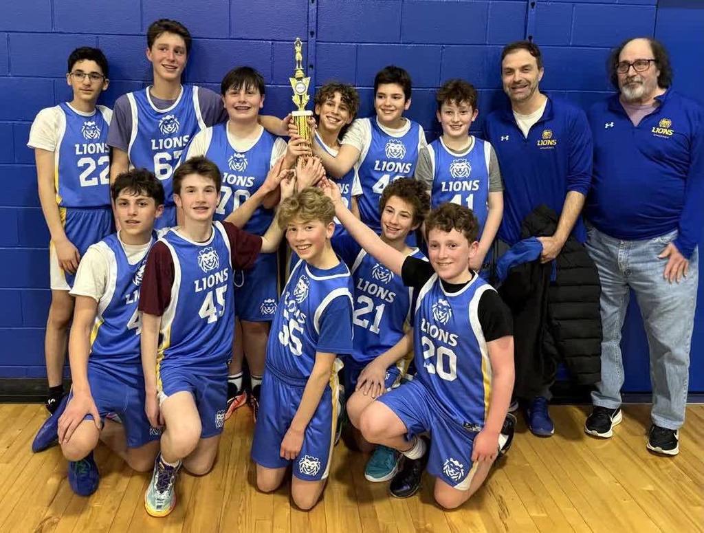 boys basketball team in blue uniforms holds first place trophy