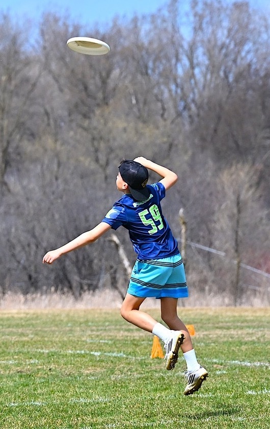 SJA ultimate player jumps for frisbee