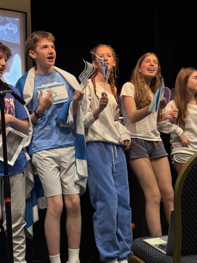 students sing and wave Israeli flags