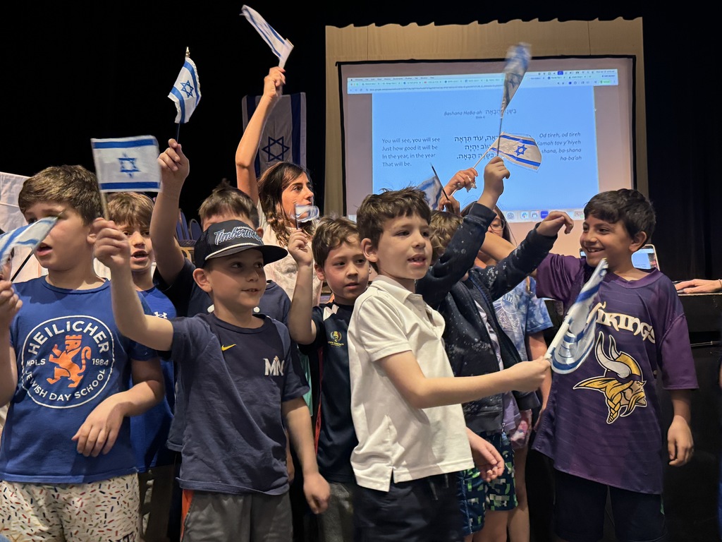students sing and wave Israeli flags