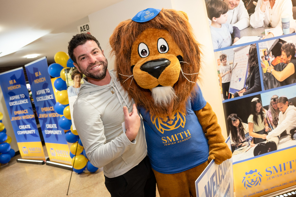 attendee poses with Roary the Lion mascot