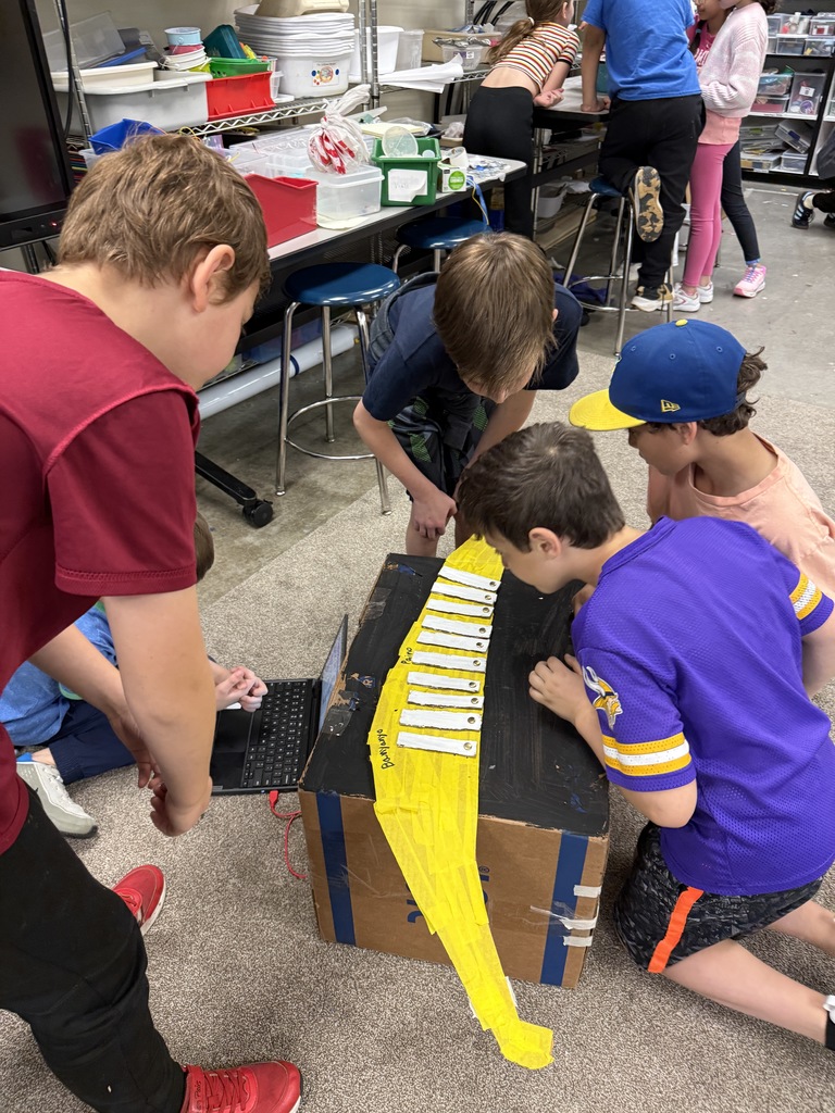 fourth graders show how their instrument works to third graders