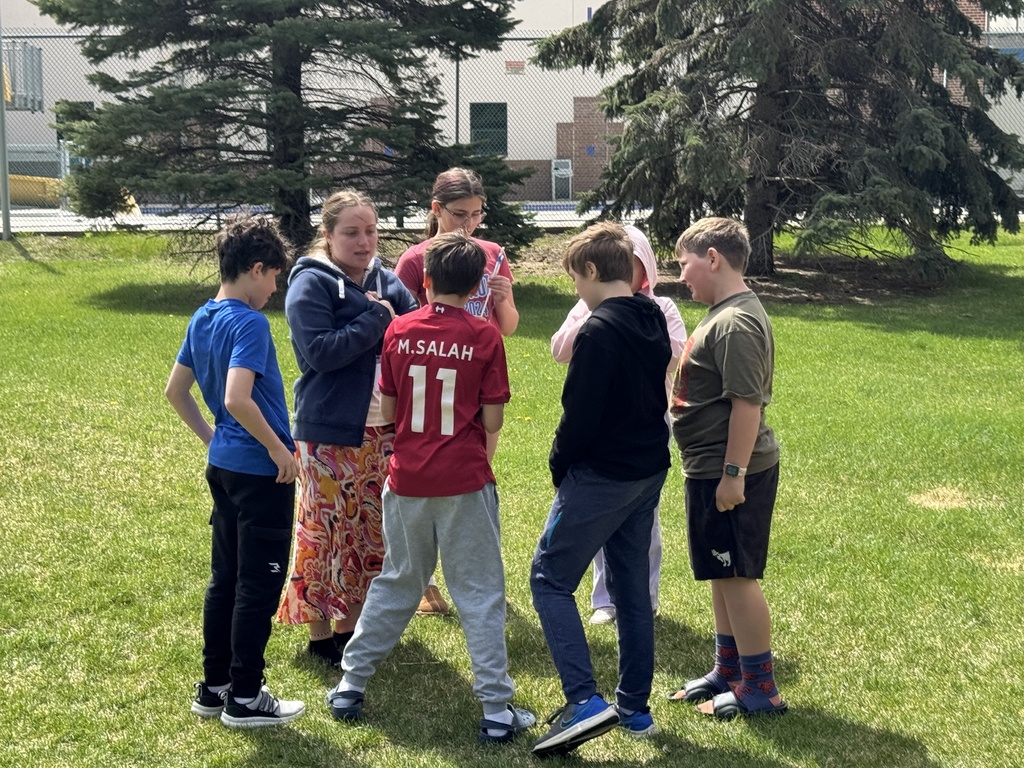 students stand in circle outside for activity