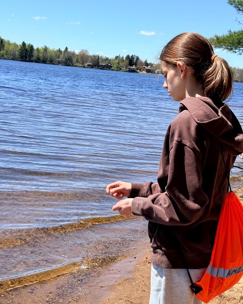 student looks for shells and other natural objects at the beach