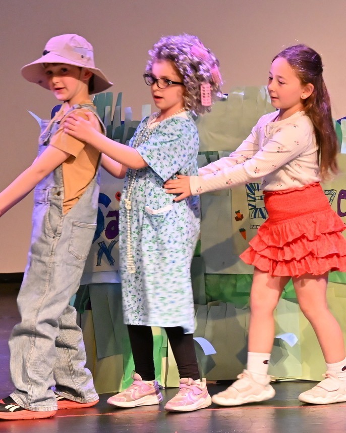 saba, safta, and girl try to pull carrot