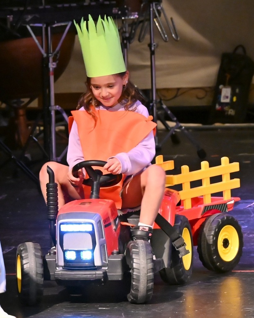 student dressed as carrot rides children's tractor
