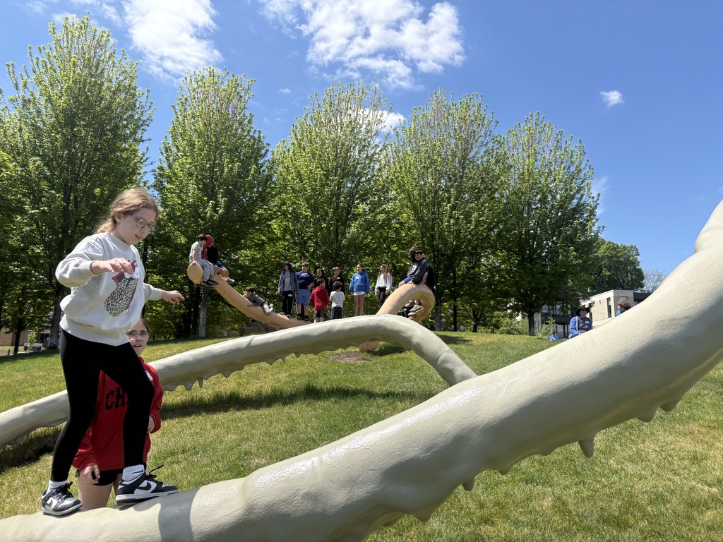fifth grader climbs Privileged Points sculpture, others sit and stand on Privileged Points sculpture in the background