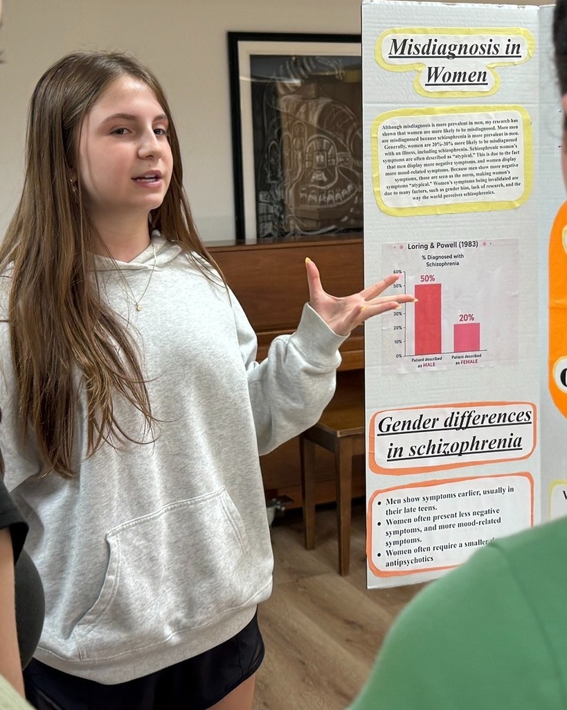 student presents poster with poster board