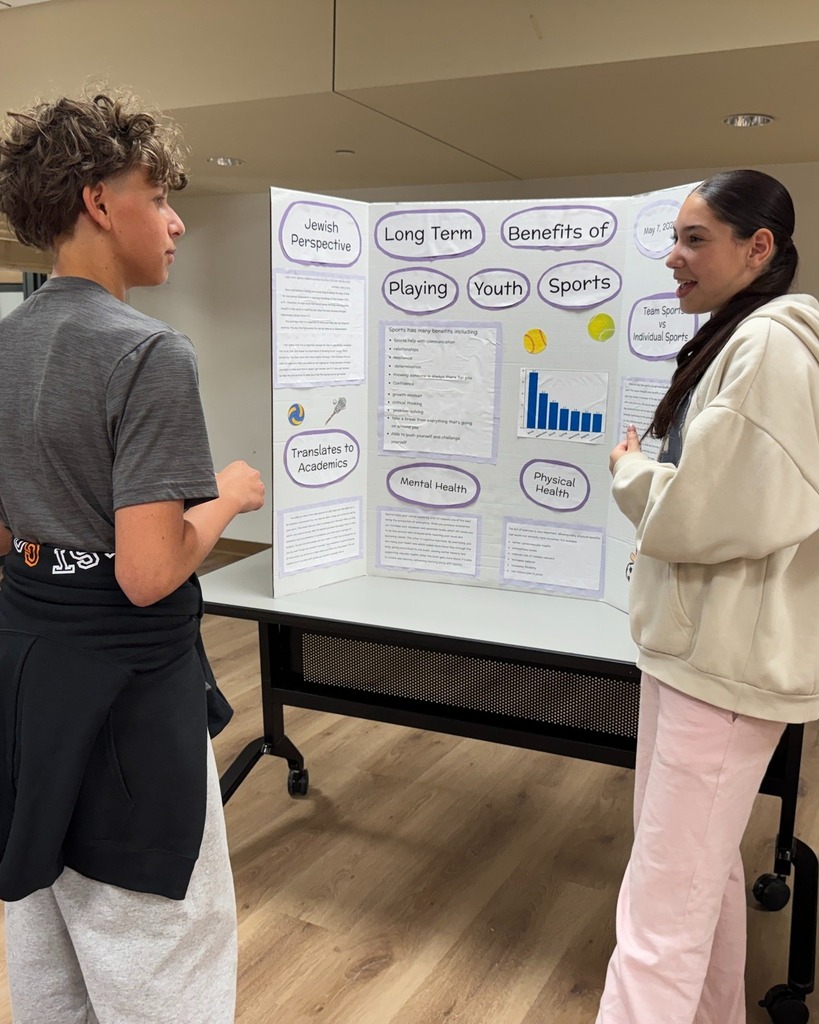 student presents poster with poster board