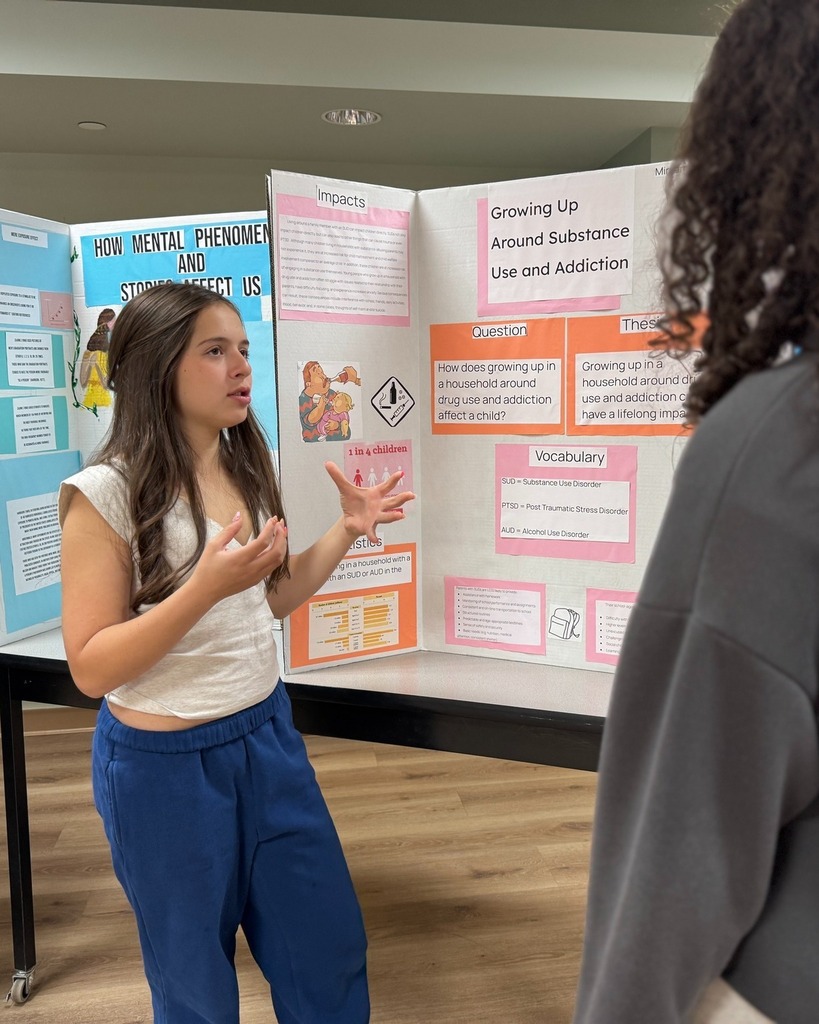 student presents poster with poster board