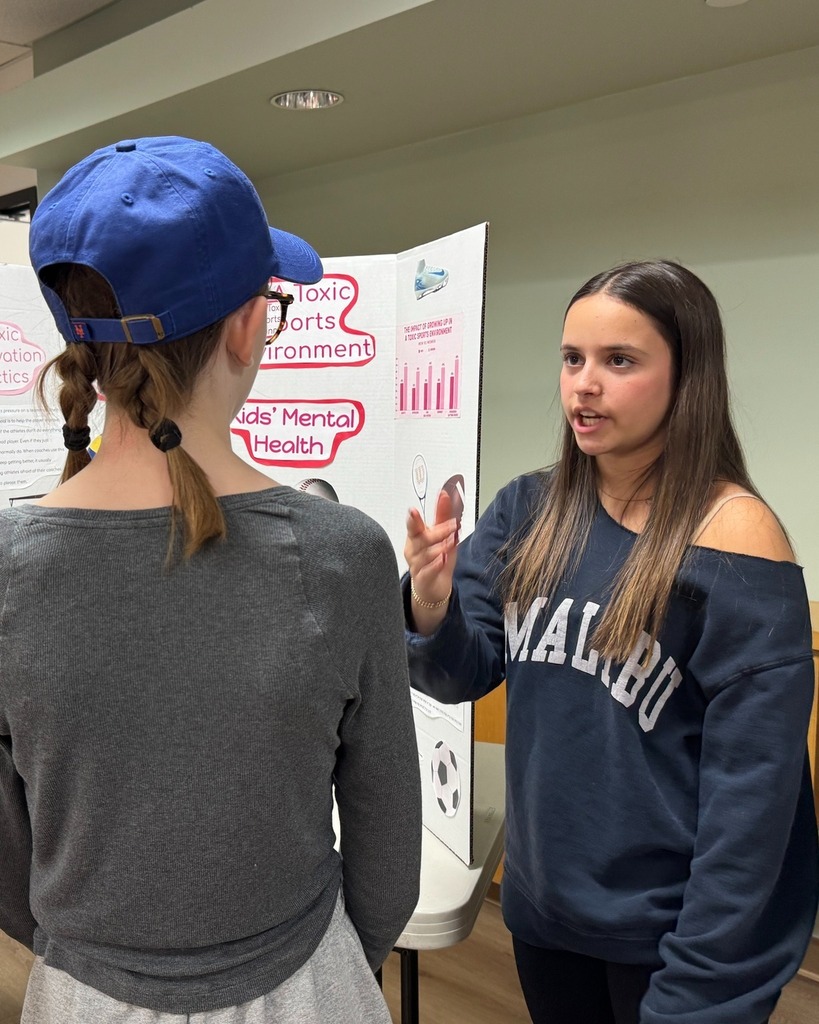 student presents poster with poster board