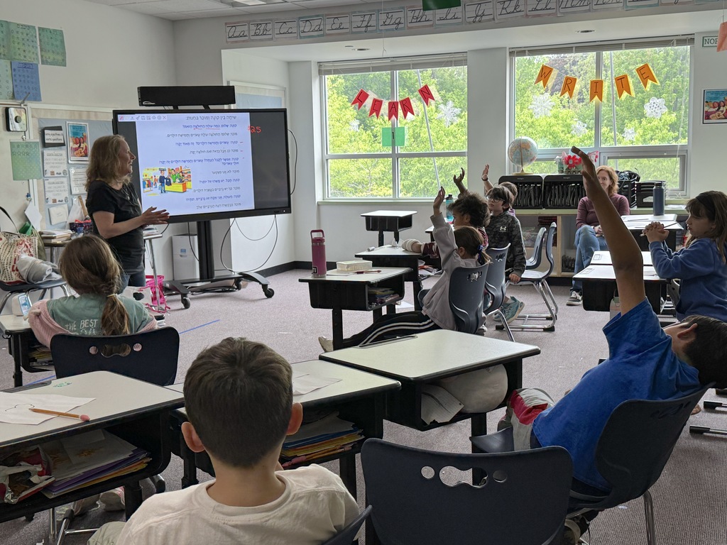Author Dori Weinstein speaks as students raise hands