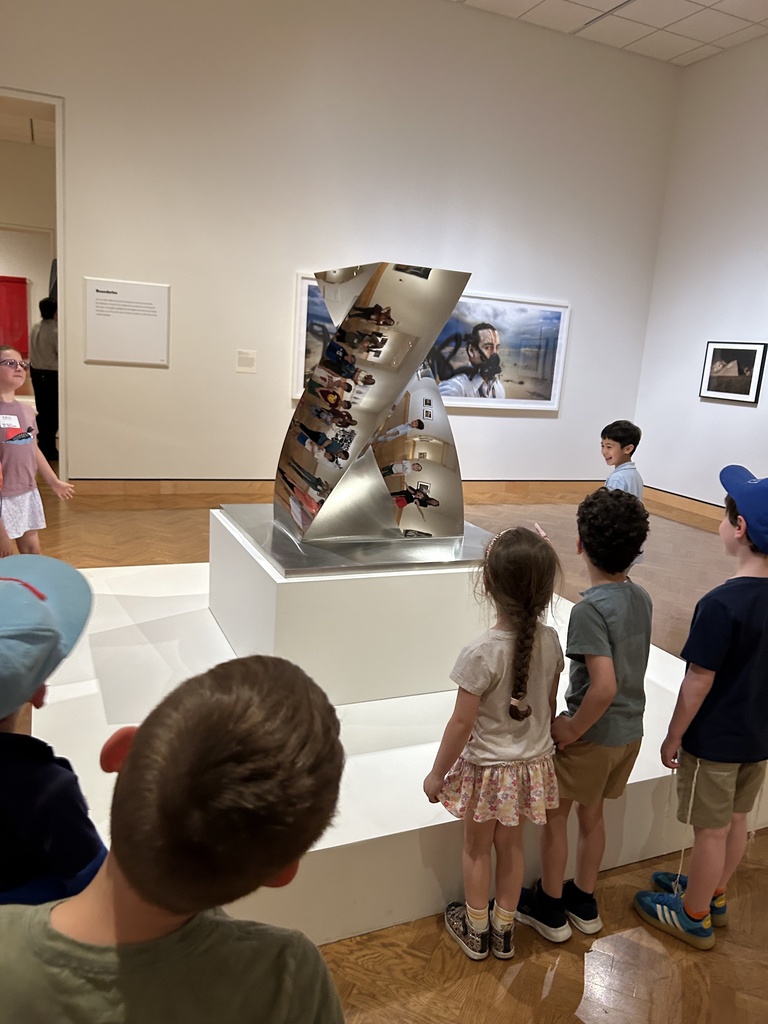students look at mirror sculpture